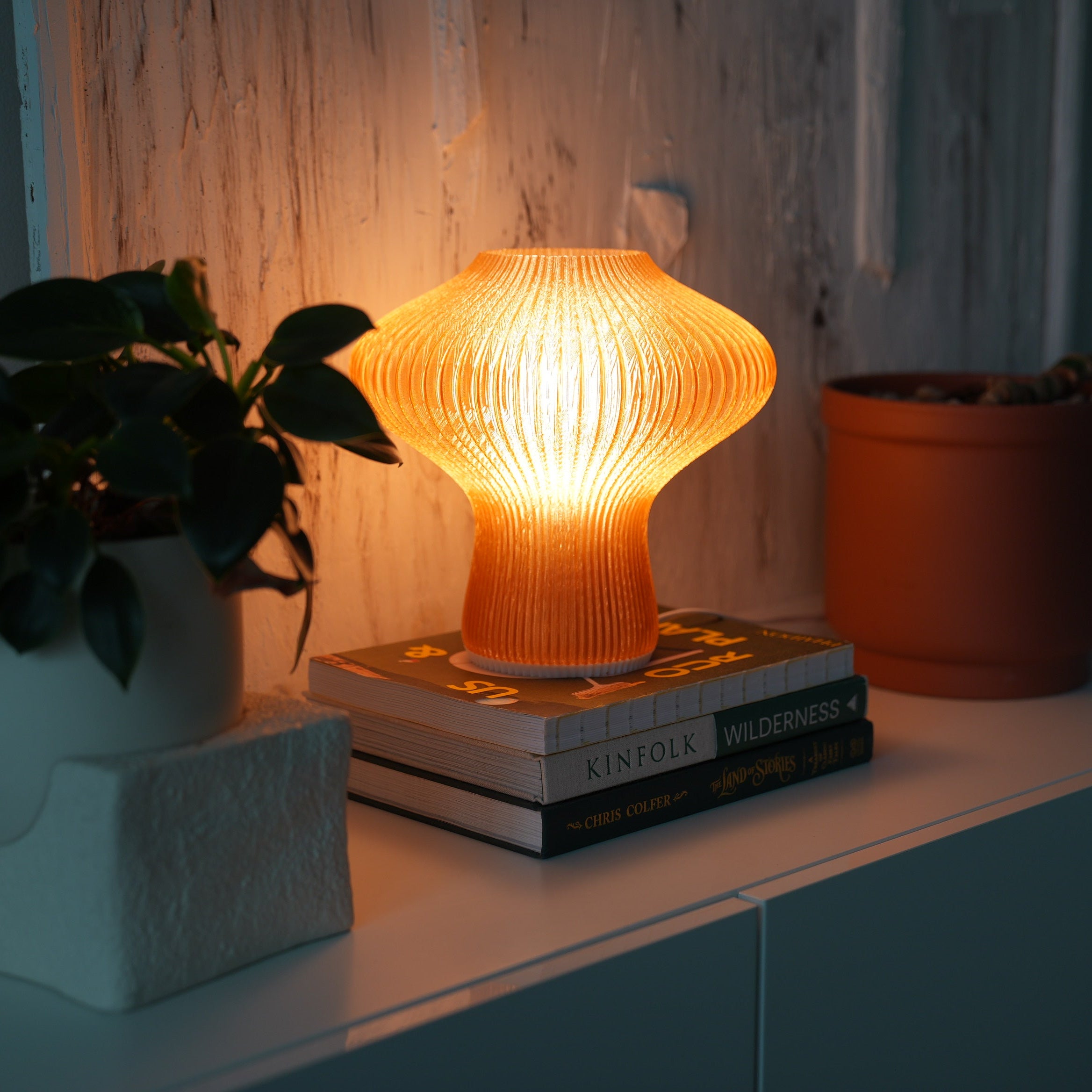 NAMU lamp casting a warm glow against a textured plaster wall